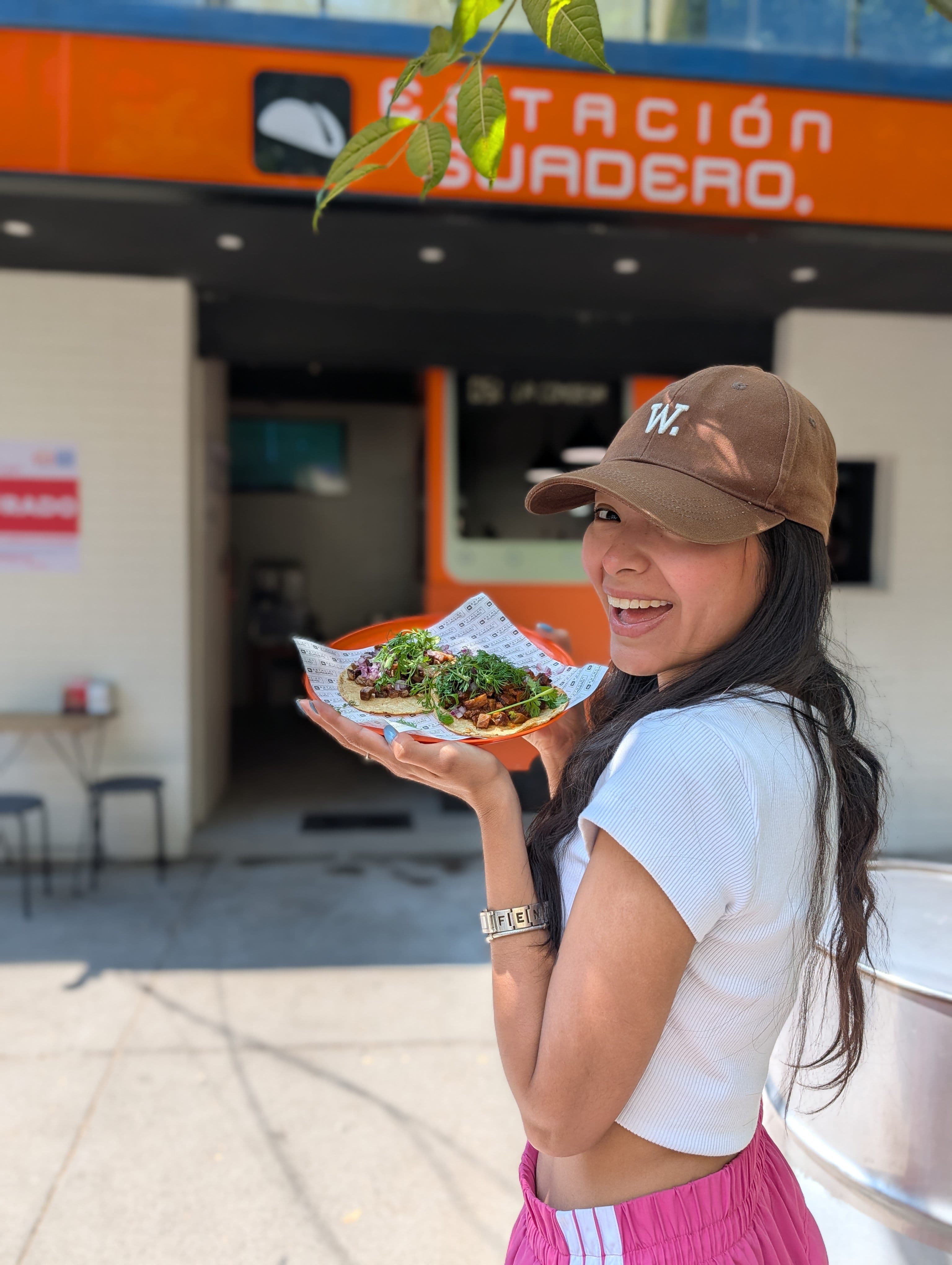 Linda holding a plate of tacos outside a taquería in Mexico City